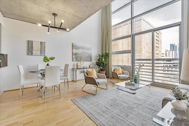 interior space featuring wood-type flooring, floor to ceiling windows, a wealth of natural light, and an inviting chandelier