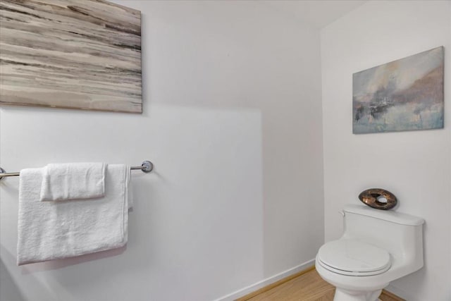 bathroom featuring wood-type flooring and toilet