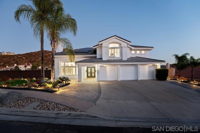 view of front facade with a garage and solar panels