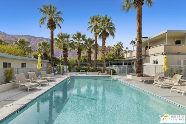 view of pool with a mountain view and a patio