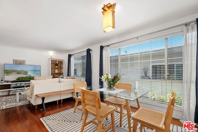 dining space featuring dark wood-type flooring and ornamental molding