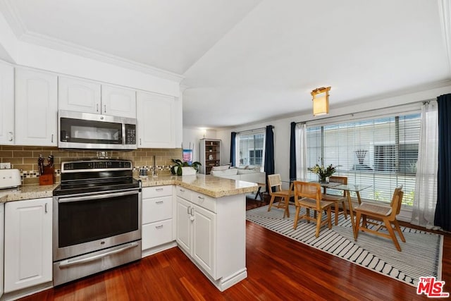 kitchen featuring stainless steel appliances, white cabinetry, backsplash, and kitchen peninsula