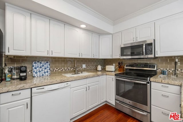 kitchen with stainless steel appliances, white cabinetry, sink, and tasteful backsplash