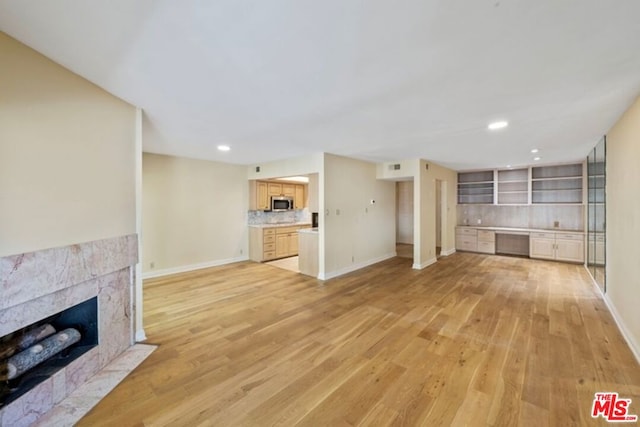 unfurnished living room with a tile fireplace and light hardwood / wood-style floors