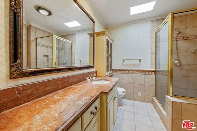 bathroom with crown molding, tile walls, tile patterned floors, and a skylight