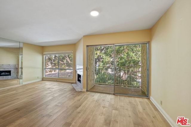 unfurnished living room with a fireplace and light wood-type flooring