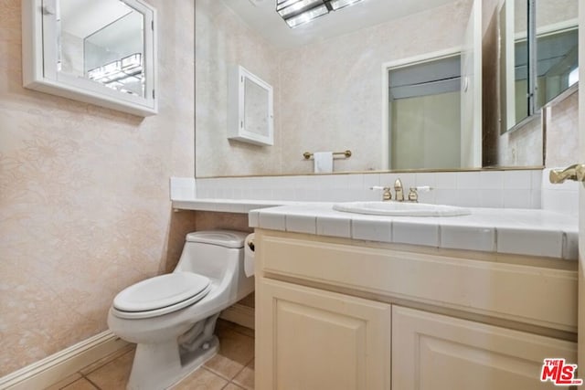 bathroom featuring vanity, toilet, and tile patterned flooring