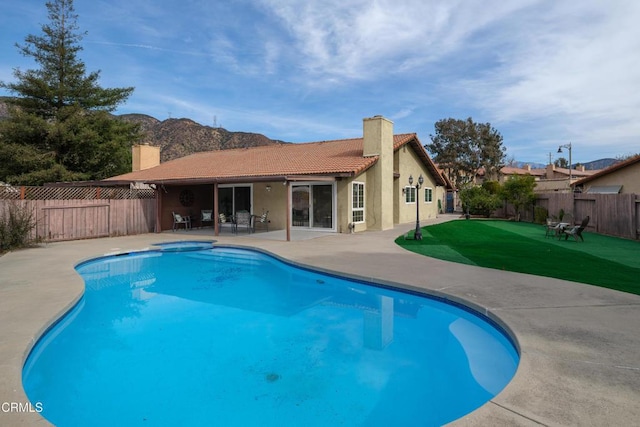 view of pool with a hot tub, a patio, and a lawn