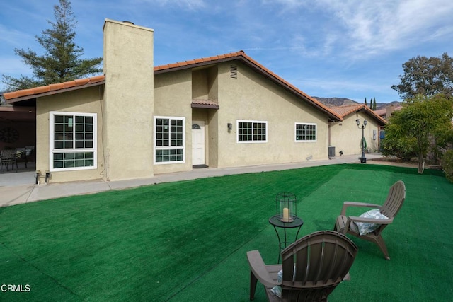 back of house featuring a patio area and a lawn