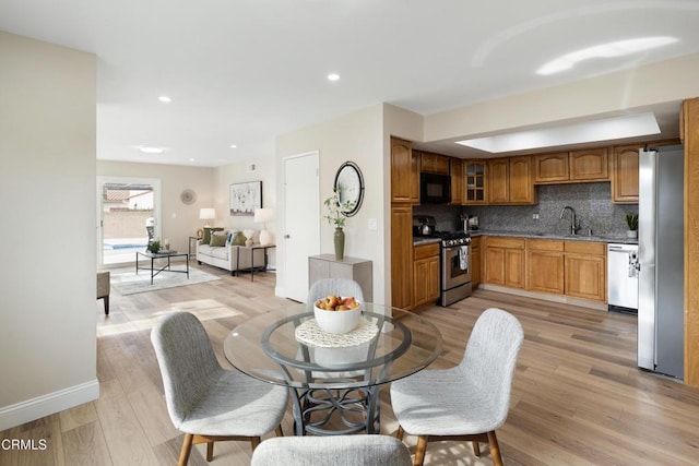 dining room with sink and light wood-type flooring