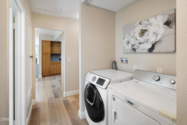 laundry room with separate washer and dryer and light wood-type flooring