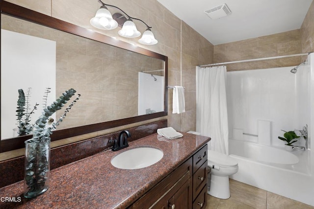 full bathroom with shower / bath combo, tile walls, vanity, tile patterned floors, and toilet