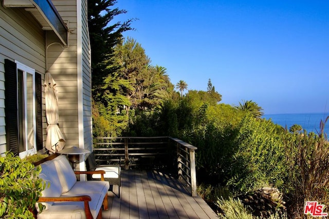 wooden terrace featuring a water view