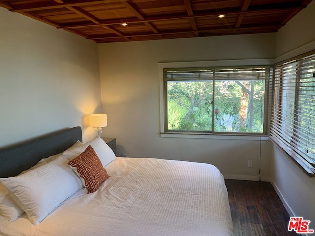 bedroom with coffered ceiling and dark wood-type flooring