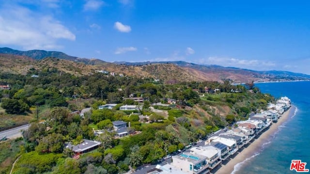 drone / aerial view featuring a water and mountain view and a view of the beach