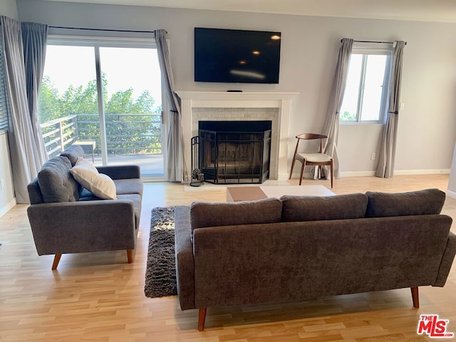 living room with light hardwood / wood-style flooring and a tile fireplace