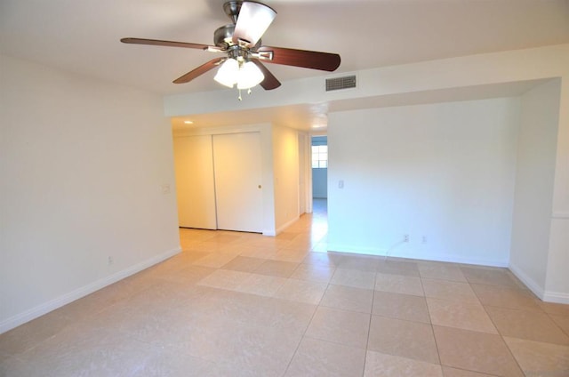 tiled spare room featuring ceiling fan