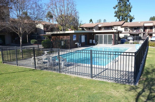 view of pool with a patio area and a lawn