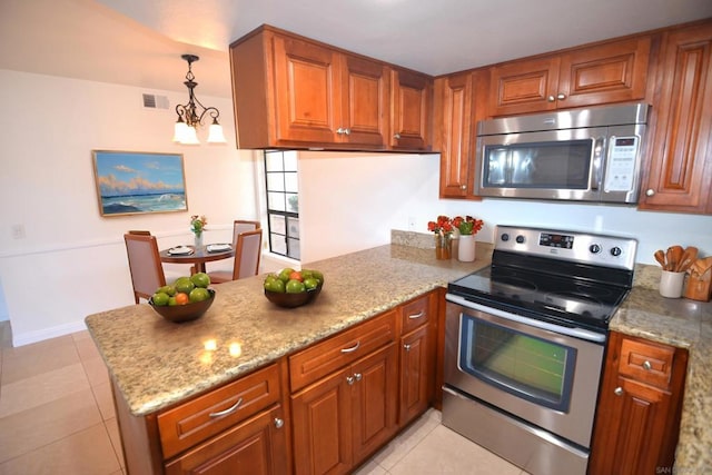 kitchen with stainless steel appliances, light stone countertops, pendant lighting, and light tile patterned floors