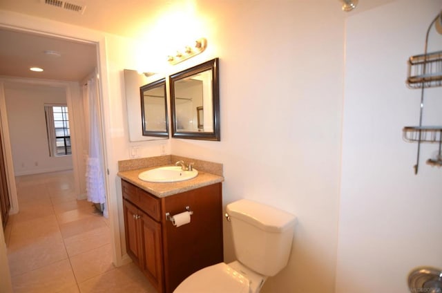 bathroom with tile patterned flooring, vanity, and toilet