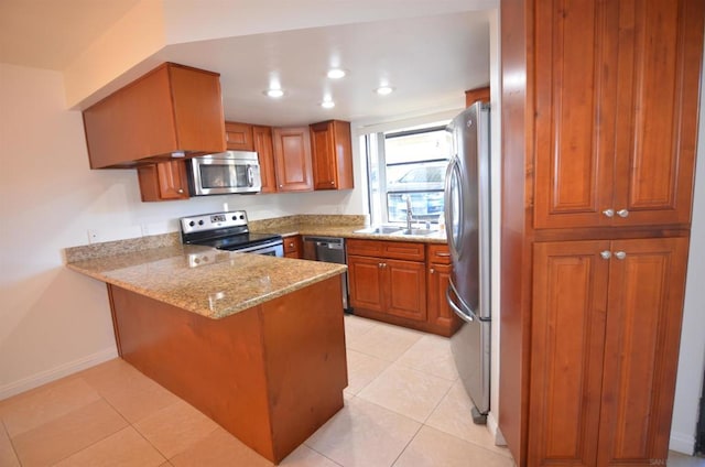 kitchen featuring sink, light tile patterned floors, appliances with stainless steel finishes, kitchen peninsula, and light stone countertops