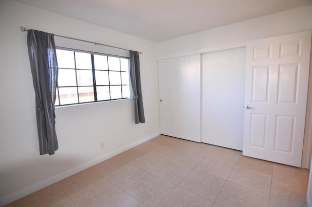 unfurnished bedroom featuring light tile patterned floors and a closet