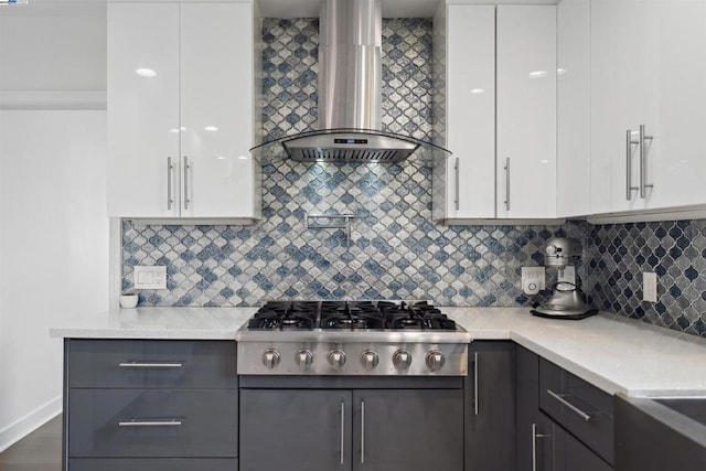 kitchen featuring tasteful backsplash, white cabinets, stainless steel gas cooktop, and wall chimney exhaust hood