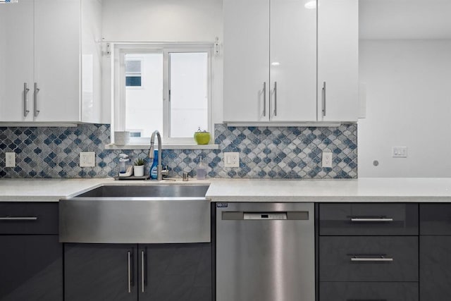 kitchen featuring stainless steel dishwasher, sink, decorative backsplash, and white cabinets