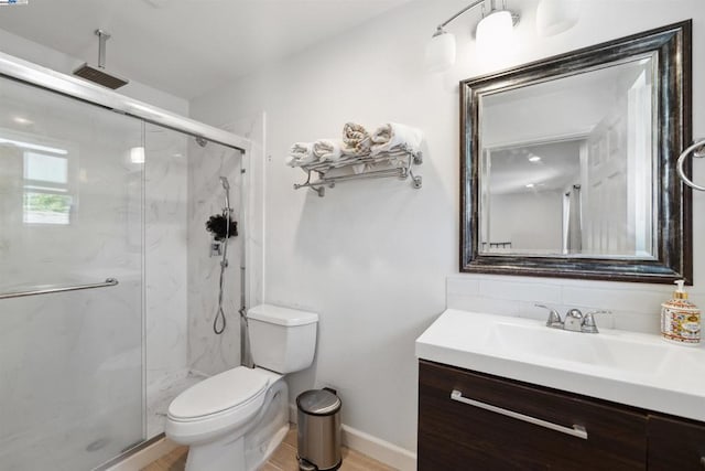 bathroom featuring vanity, toilet, and a shower with shower door