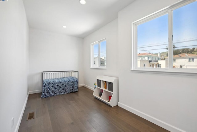 bedroom with dark hardwood / wood-style floors