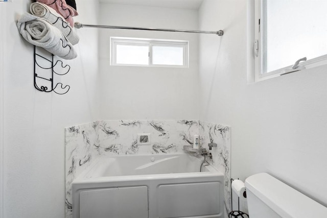 bathroom featuring toilet and a bath