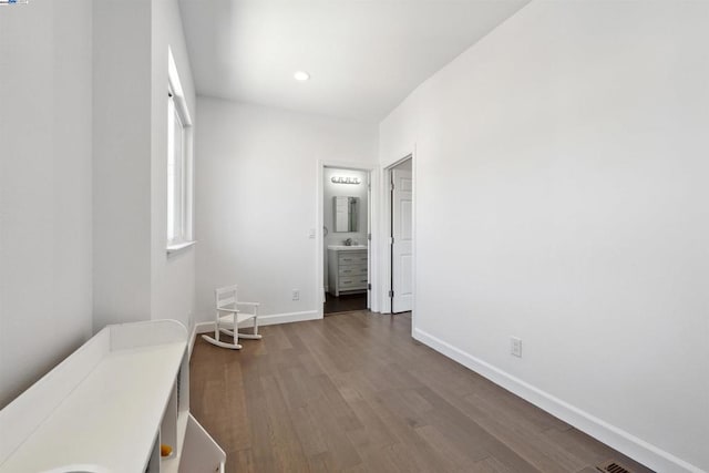 interior space featuring wood-type flooring and connected bathroom