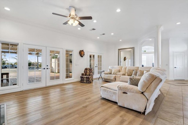 living room featuring crown molding, light hardwood / wood-style flooring, ceiling fan, and french doors