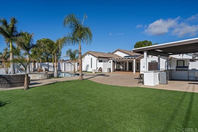 view of yard featuring a fenced in pool, a patio area, an outdoor bar, and exterior kitchen