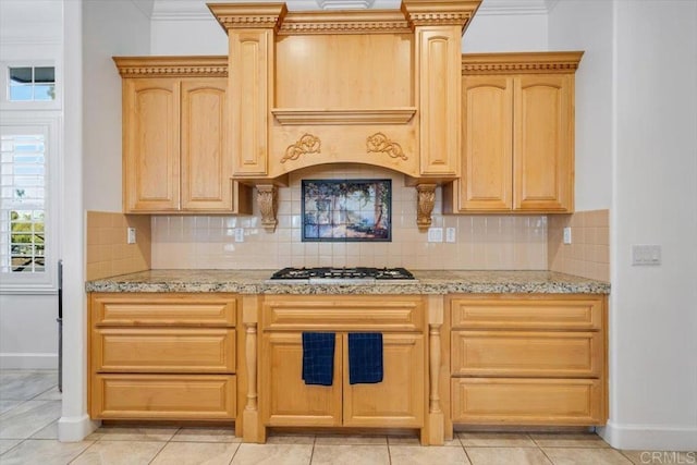 kitchen featuring decorative backsplash, light stone countertops, and light brown cabinets