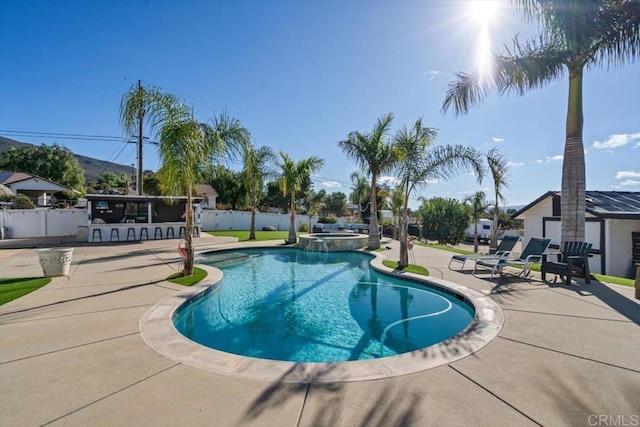 view of pool with a patio area, an outdoor bar, and an in ground hot tub