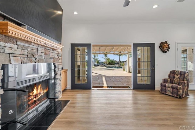 foyer featuring hardwood / wood-style floors, crown molding, and a fireplace