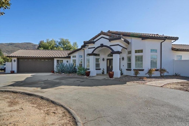 mediterranean / spanish-style home with a garage