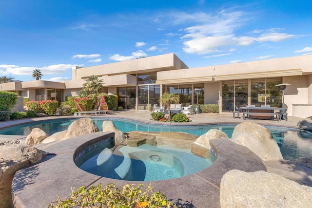 view of pool featuring a patio and an in ground hot tub