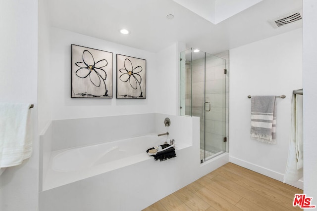 bathroom featuring hardwood / wood-style flooring and independent shower and bath