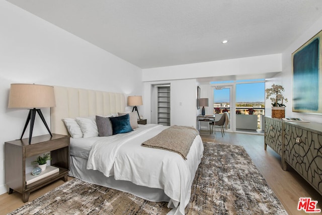 bedroom with access to exterior and light wood-type flooring