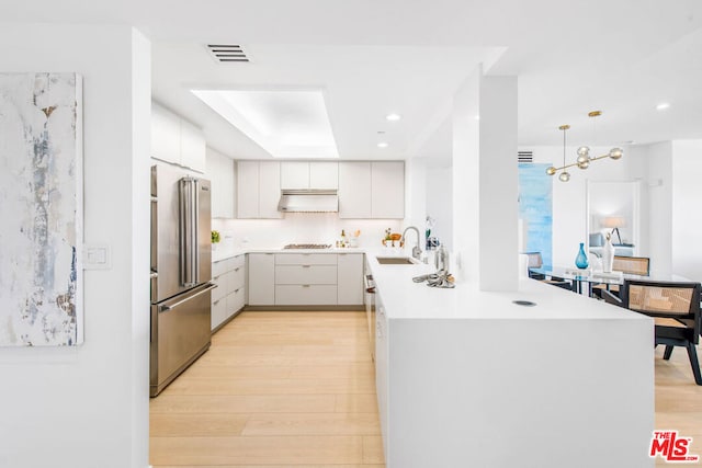 kitchen with sink, decorative light fixtures, stainless steel appliances, and white cabinets