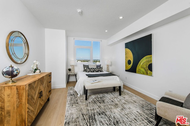 bedroom featuring a textured ceiling and light wood-type flooring