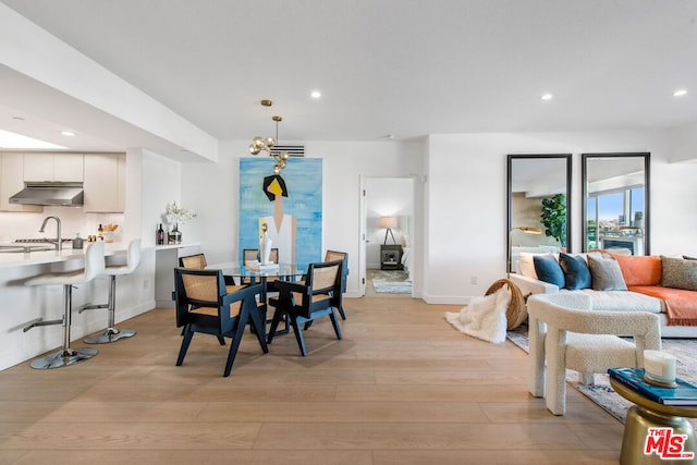 dining space with sink and light hardwood / wood-style flooring