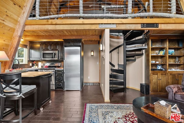 kitchen with appliances with stainless steel finishes, beamed ceiling, dark hardwood / wood-style flooring, dark brown cabinets, and wooden ceiling