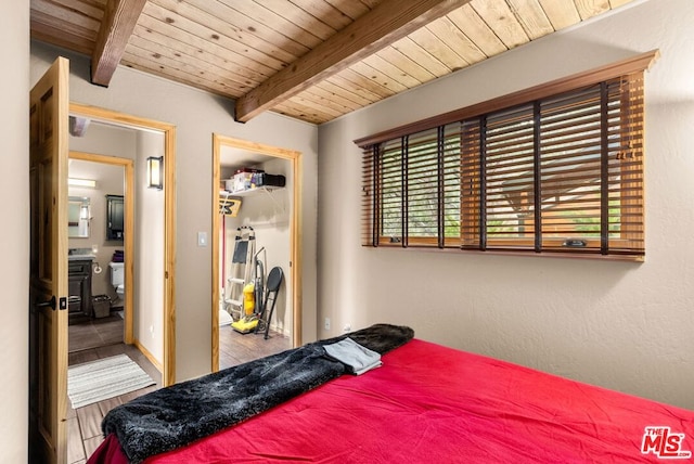 bedroom featuring beamed ceiling, hardwood / wood-style floors, and wooden ceiling