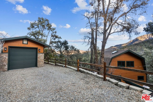 exterior space with a garage, an outdoor structure, and a mountain view