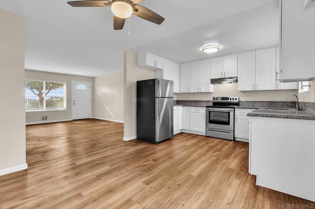 kitchen with stainless steel appliances, sink, white cabinets, and light hardwood / wood-style flooring