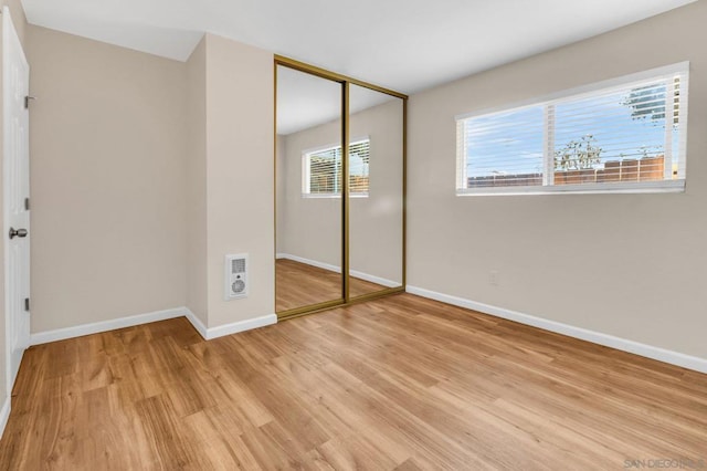 unfurnished bedroom featuring light hardwood / wood-style floors and a closet