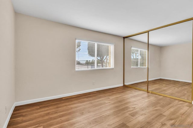 unfurnished bedroom with hardwood / wood-style flooring and a closet